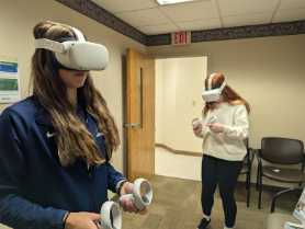 Two students use virtual reality headsets in a classroom