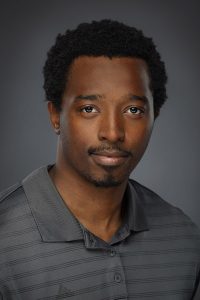 A man with black shirt and a grey polo shirt smiling
